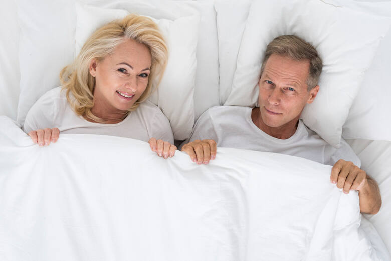 Kobieta i mężczyzna w średnim wieku leżą w łóżku