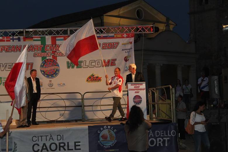 Paweł Tomczyk wchodzi na scenę jako chorąży reprezentacji Polski podczas rozpoczęcia mistrzostw świata w Carole