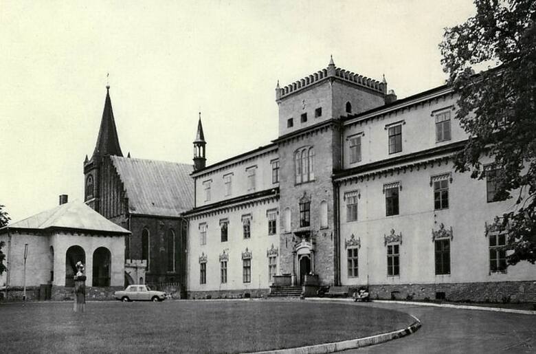 Widok na front pałacu i kościół parafialny w latach 60. ub. wieku