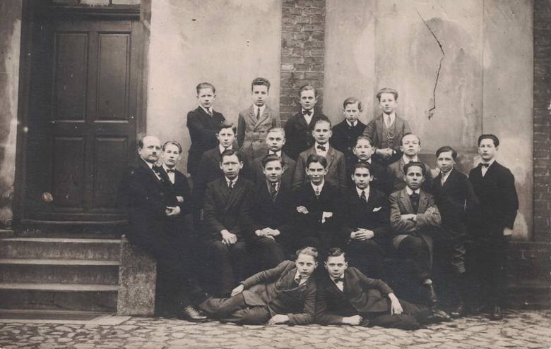 Około 1925 r. - szkoła fryzjerska. Po lewej na murku siedzi nauczyciel zawodu fryzjer, p. Woźniak.  Swój zakład miał przy ul. Sienkiewicza. Alfred Tasarek leży - po lewej stronie  