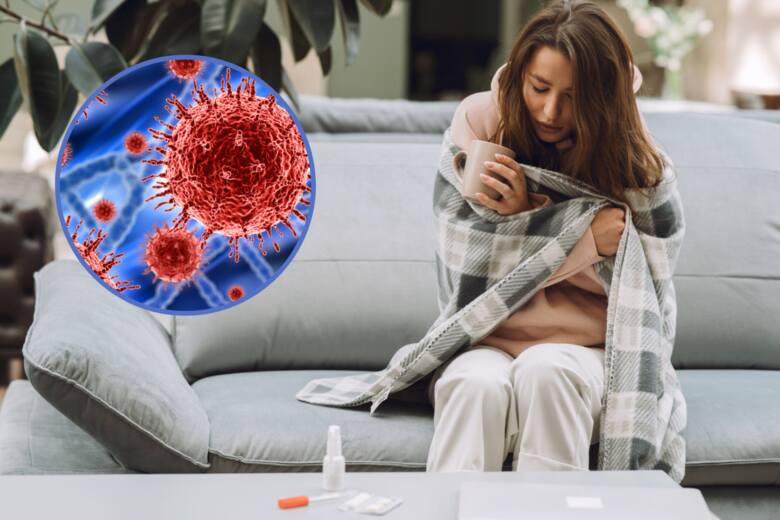 Chora kobieta siedzi na kanapie okryta kocem, w kółku wirus