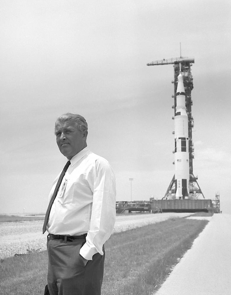 Wernher von Braun pozujący na tle rakiety Saturn V.