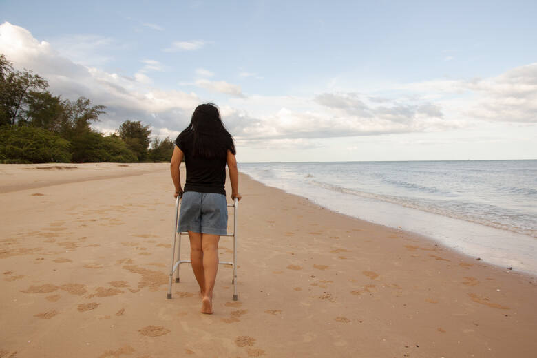 Kobieta z chodzikiem na plaży