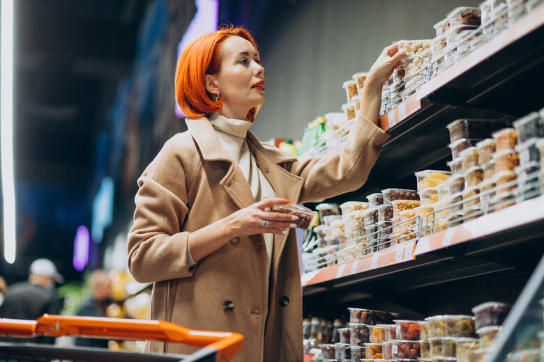 Kobieta robi zakupy z wózkiem w supermarkecie