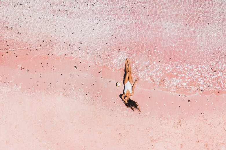 Kobieta leżąca na różowym piasku (Komodo, Indonezja)