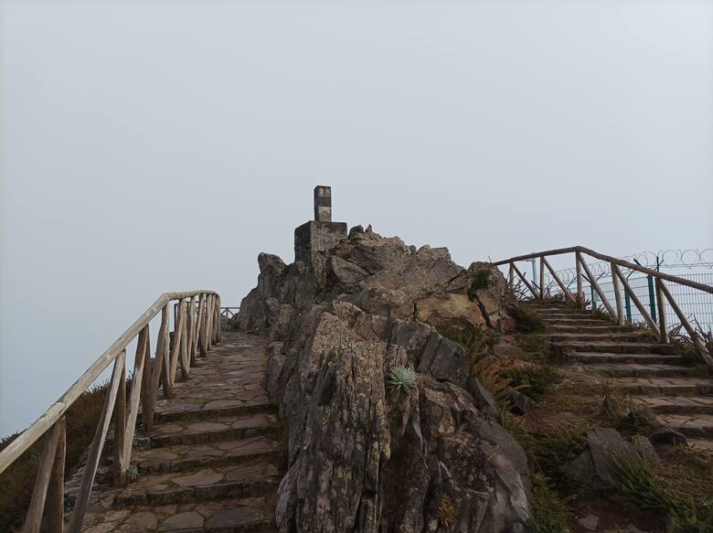 Pico de Arieiro ma 1818 metrów wysokości. Szczyt znaczy kamienny filar, na który można wejść. Z boku przybita jest tabliczka z informacją, że należy