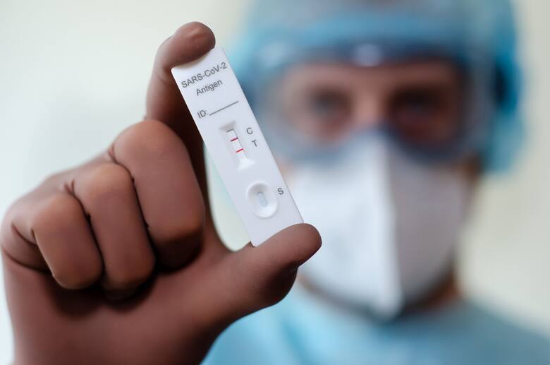 Lekarz trzyma w ręku pozytywny test na COVID-19