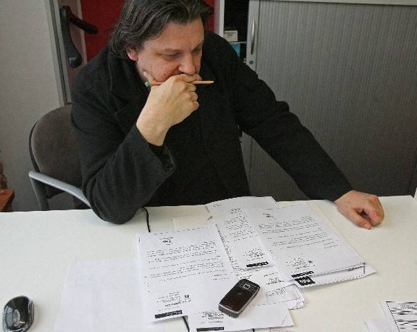 Jacek Kłak przegląda korespondencję z operatorem komórkowym Play, który kazał mu płacić rachunki za telefony sprzedane przez firmę na podstawie sfałszowanych umów. 