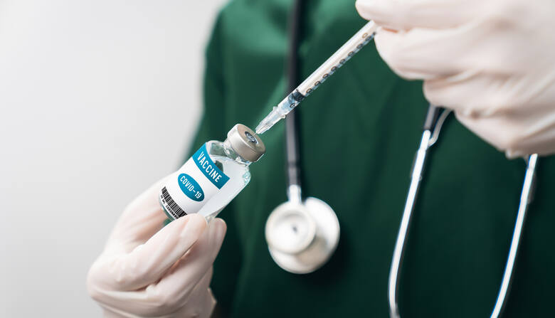Lekarz ze strzykawką i fiolką szczepionki na COVID-19