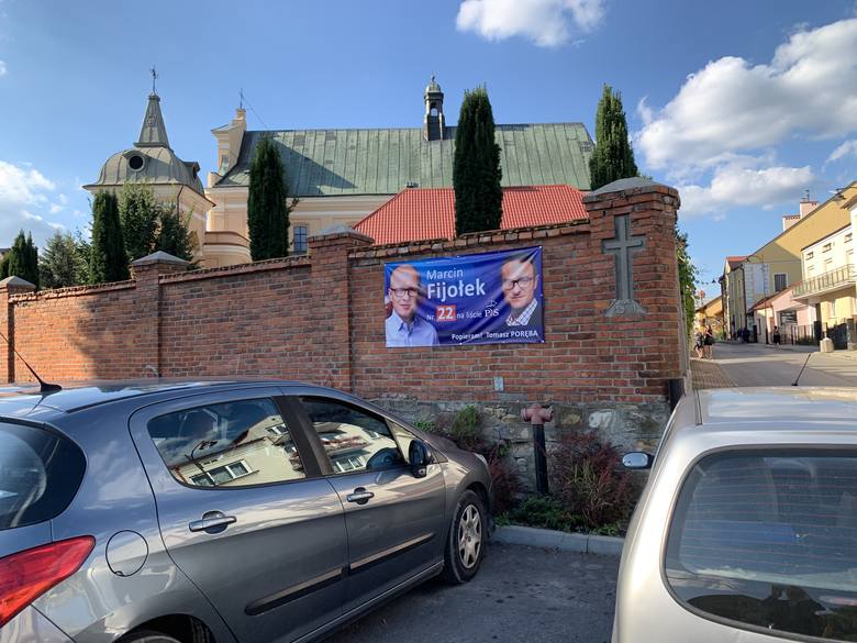 Baner wyborczy Marcina Fijołka z PiS na murze kościoła w Tyczynie.