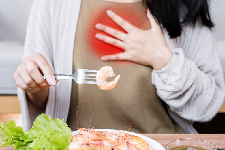 Kobieta cierpi na objawy alergii przy jedzeniu krewetek