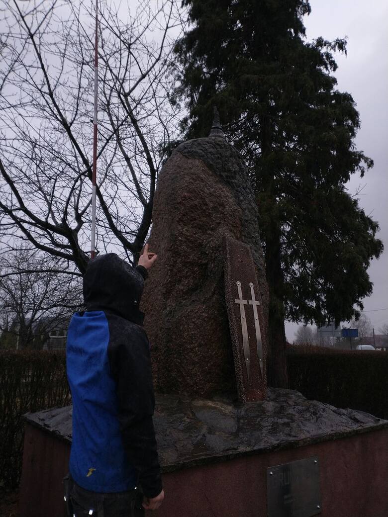 Sprawca wskazuje miejsce na pomniku, z którego oderwał się krzyż