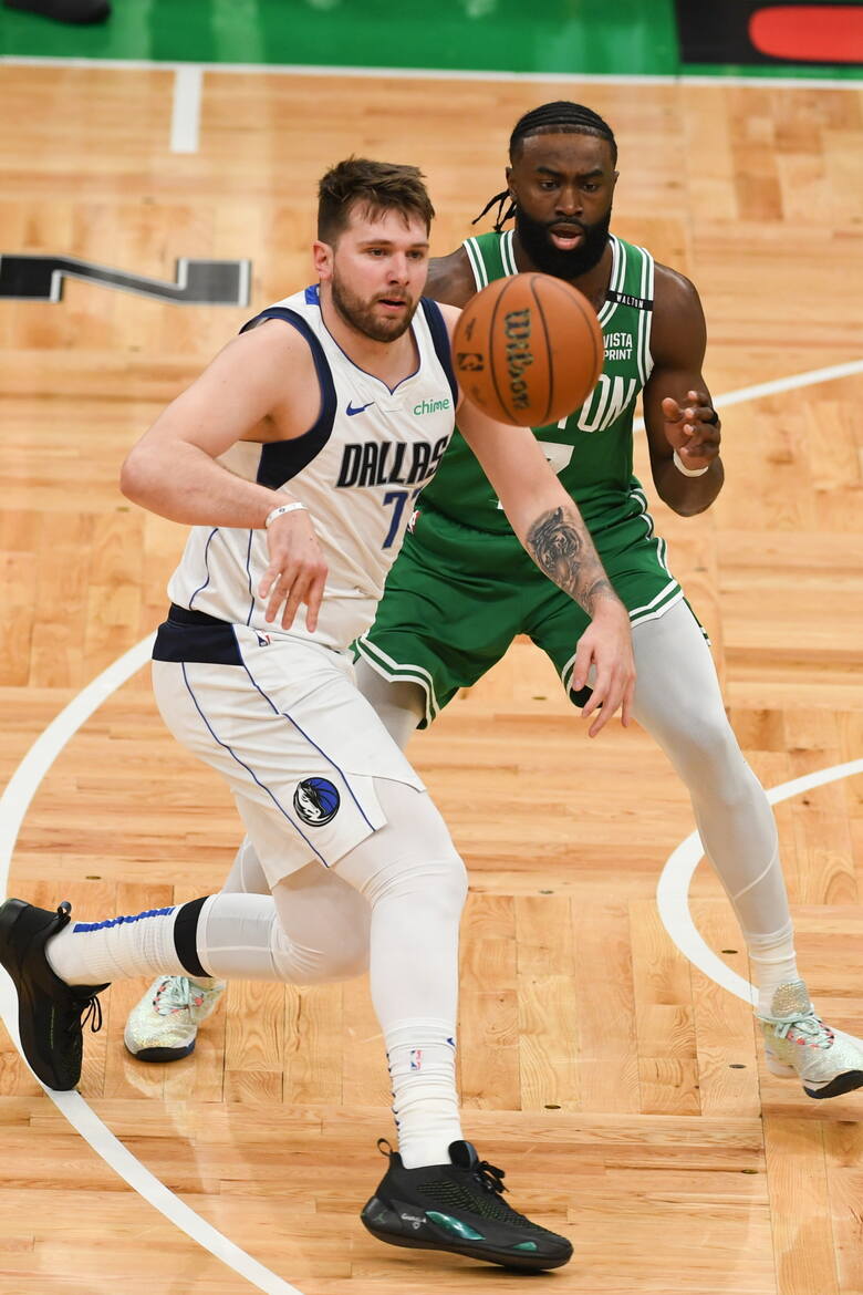 Obrońca Dallas Mavericks Luka Doncić wykonuje podanie przy obrońcy Boston Celtics Jaylenie Brownie
