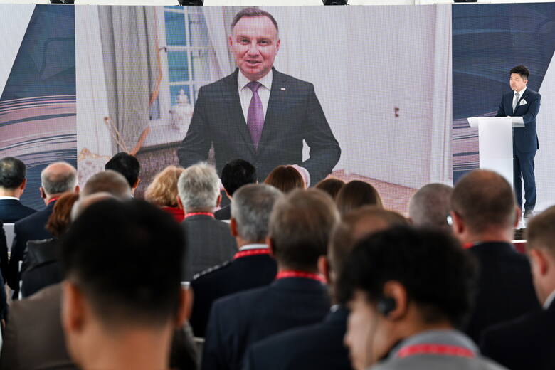 Prezydent RP Andrzej Duda (na ekranie) podczas uroczystej inauguracji budowy fabryki firmy SK Nexilis, w której produkawana będzie folia miedziana do