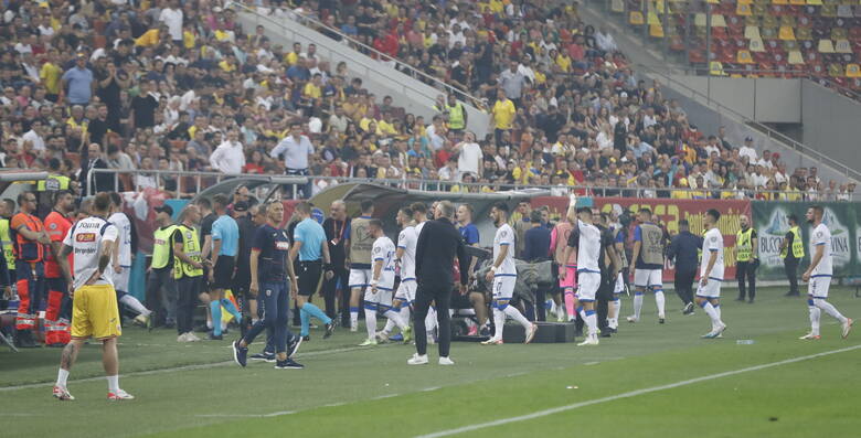 Piłkarze reprezentacji Kosowa schodzący z boiska do szatni w proteście wywieszenia przez rumuńskich fanów drażliwego transparentu