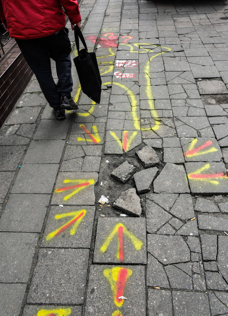 W ostatnim czasie na zniszczonych płytach chodnikowych przy ul. Cieszkowskiego w Bydgoszczy pojawiły się kolorowe strzałki i napisy, między innymi „Moja ulica”, „Centrum Miasta”.