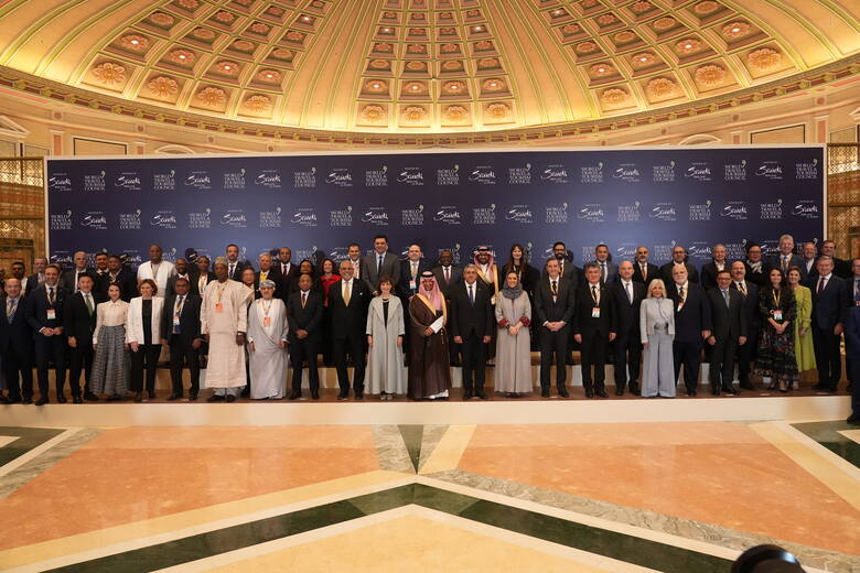 Pośrodku w tradycyjnym nakryciu głowy stoi minister turystyki Arabii Saudyjskiej, Ahmed Al Khateeb, po jego prawej ręce Julia Simpson, CEO WTTC, po jej