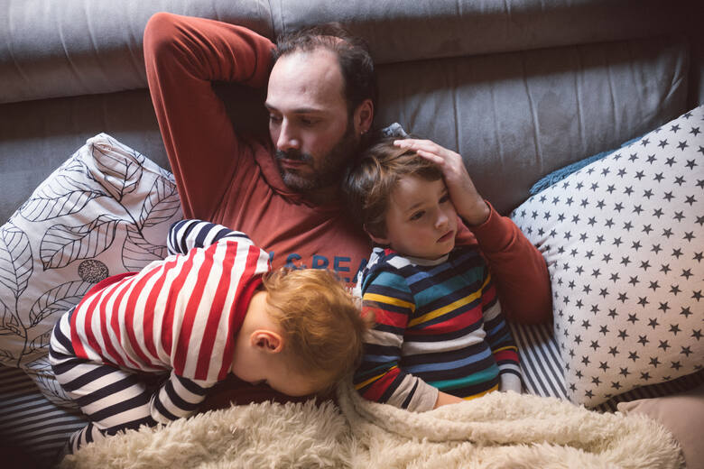 Ojciec odpoczywa z dziećmi na sofie