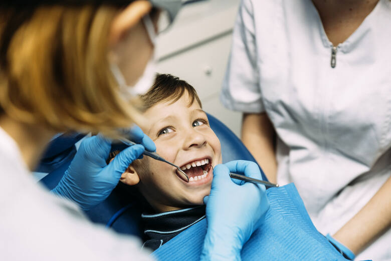 Dziecko na fotelu dentystycznym podczas badania stomatologicznego