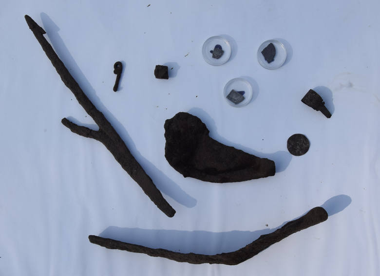 Fragmenty monet, podkowy, elementy broni oraz rzeczy codziennego użytku znalezione podczas badań archeologicznych w Grodziszczu koło Świebodzina.