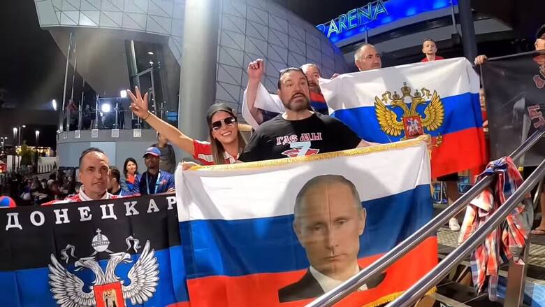 Rosyjscy fani z flagami Rosji i symbolami inwazji na Ukrainę przed wejściem na kort centralny w Melbourne Park
