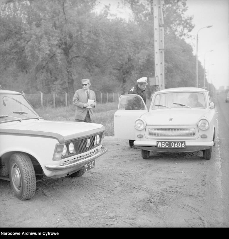 <strong>Trabant 601, 1977 rok</strong><br /> <br /> <i>Milicjant kontroluje dokumenty kierowcy samochodu Trabant 601. Obok widoczny dziennikarz i radiowóz Fiat 125p.</i><br /> <br /> Trabant (po prawej) – marka samochodów osobowych produkowanych w Niemieckiej Republice Demokratycznej w latach 1957–1991...