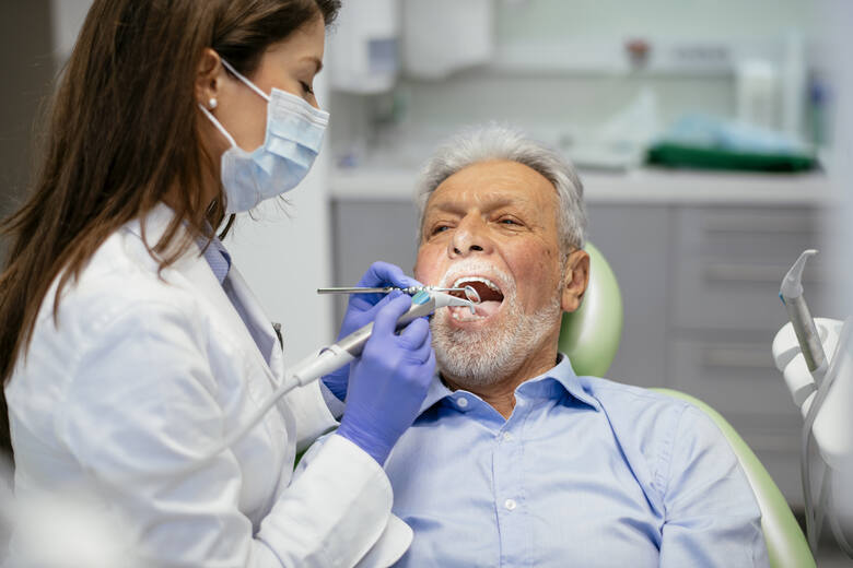 Starszy mężczyzna na fotelu dentystycznym u stomatologa