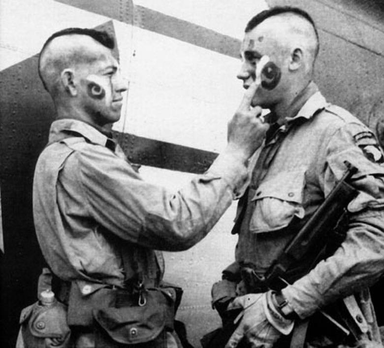 Żołnierze „Brudnej Trzynastki” malują sobie twarze przed wejściem do samolotu (5 czerwca 1944 r.)