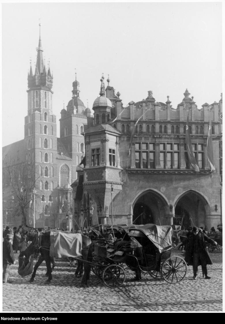 <strong>Kraków, 1939-1942</strong><br /> <br /> Kraków. Rynek Główny. Na pierwszym planie dorożki na postoju, na drugim Kościół Mariacki i Sukiennice.