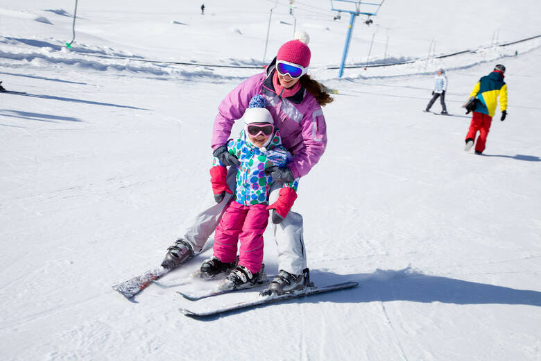 Kobieta z dzieckiem na nartach