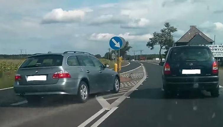Kierowca BMW E61 wciska się między wysepkę a Opla Zafirę