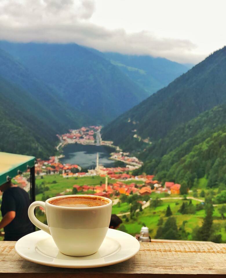 Filiżanka kawy na tle miasteczka w górach