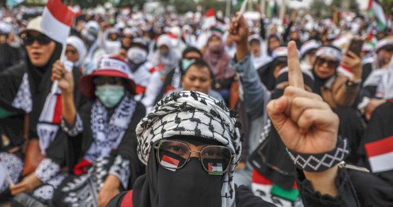 Wierni muzułmanie biorący udział w wiecu poparcia narodu palestyńskiego w Dżakarcie, stolicy Indonezji. Protestujący wyszli na ulice, potępiając Izrael