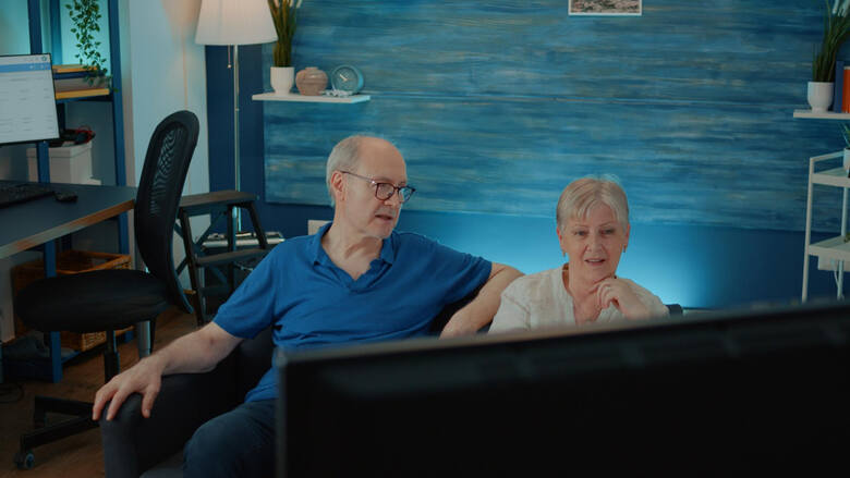 Starsza para ogląda film w telewizji