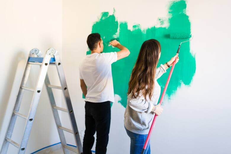 chłopak i dziewczyna malują ścianę