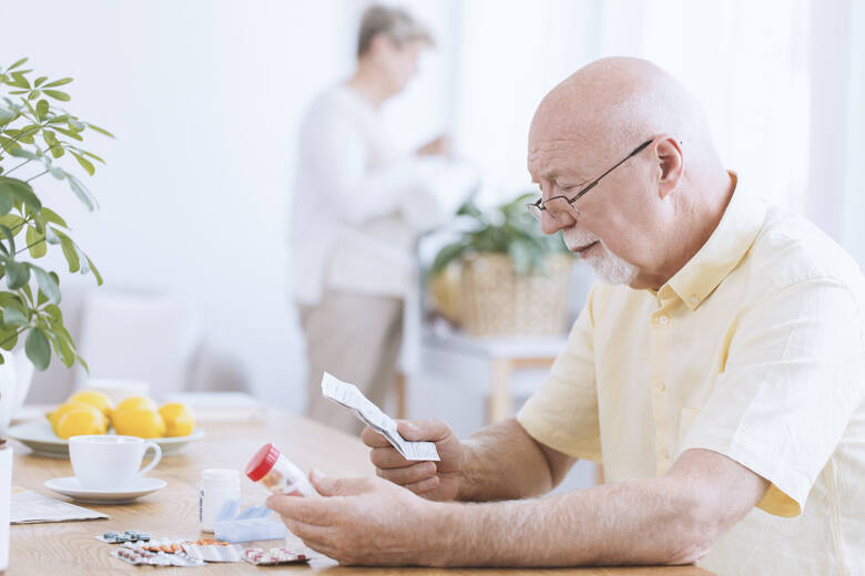 Starszy mężczyzna czyta ulotkę do leków