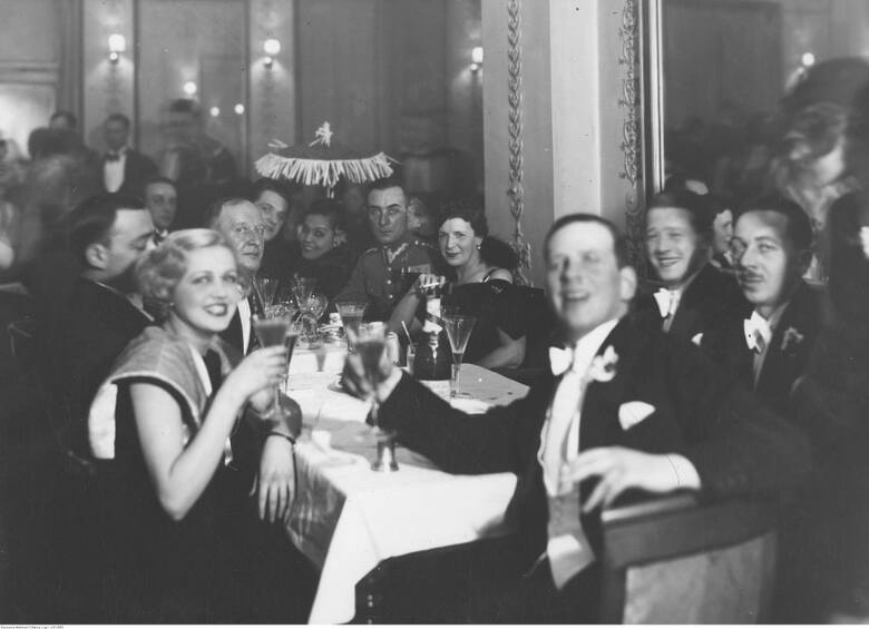 Bal Karnawałowy w Adrii. Grupa uczestników balu przy stoliku. Widoczny m.in. aktor Eugeniusz Bodo (siedzi przy stole 4. z lewej)