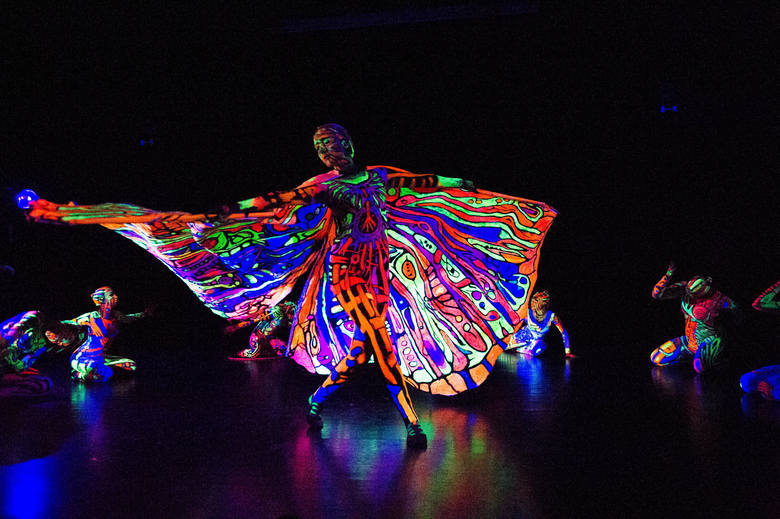 Zdjęcie pochodzi ze spektaklu „Fluo” w reż. i choreogr. Mariana Folgi, Moniki Adamczyk i Anna Banasik . Połączenie tańca z bodypaintingiem. Ciała i kostiumy tancerzy świecą w ciemności. 