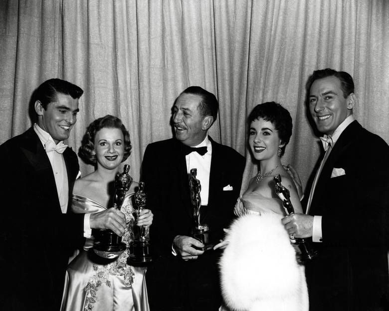 Keefe Brasselle, Marilyn Erskine, Walt Disney, Elizabeth Taylor i Michael Wilding podczas 26. gali wręczenia Oscarów w 1954 r.<br /> <br /> Aktorzy pozują do zdjęcia z Waltem Disneyem, który tego dnia otrzymał aż cztery statuetki.<br /> <br /> Disney otrzymał w swojej karierze 22 Oscary (i 59...