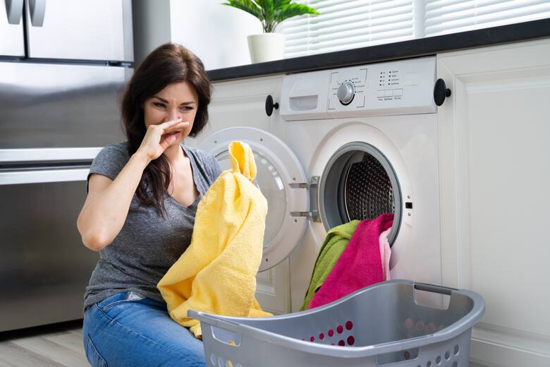 pani wyjmujące pranie z pralki