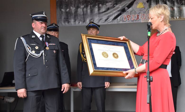 Iwona Gibas wręcza złoty medal "Polonia Minor" od władz wojewódzkich w Małopolsce