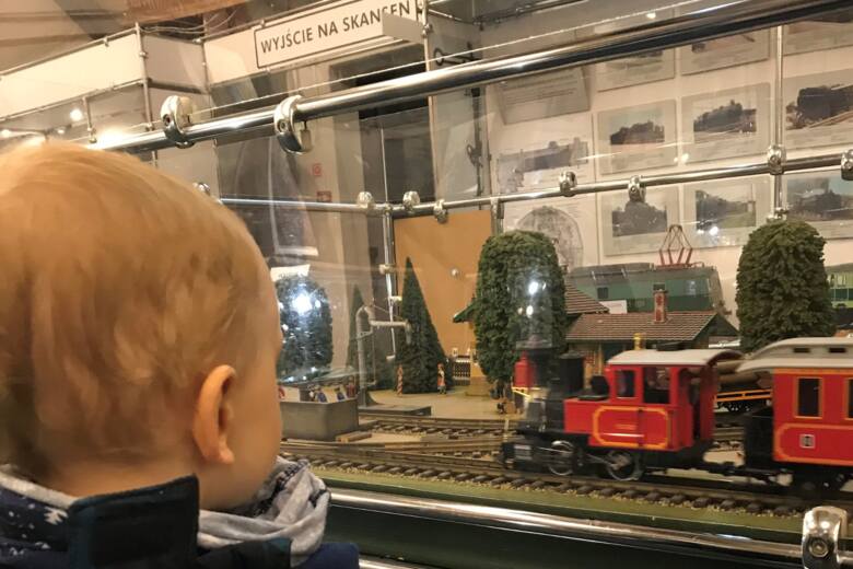 Dziecko patrzy na pociąg-makietę. 