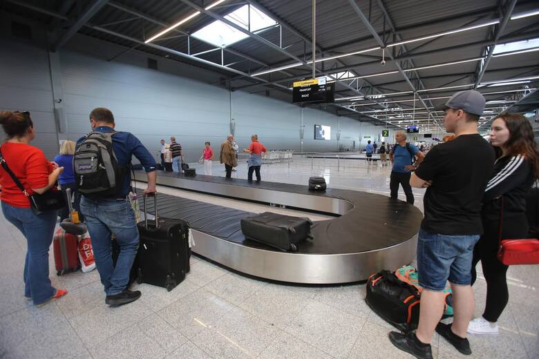 Turyści czekający na walizki na lotnisku w Katowicach
