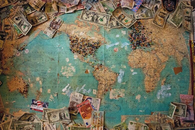 Mapa świata z rozrzuconymi pieniędzmi