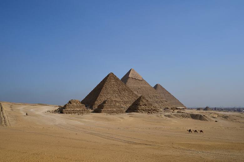 W Gizie stoją trzy najsłynniejsze egipskie piramidy. Na zdjęciu na pierwszym planie widać pomniejsze piramidy satelitarne, za nimi piramidę Mykerinosa,