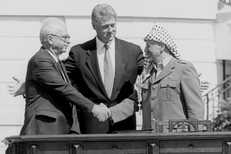 Icchak Rabin i Jasir Arafat podający sobie ręce w obecności prezydenta USA Billa Clintona. Ten gest premiera Izraela i przywódcy Organizacji Wyzwolenia