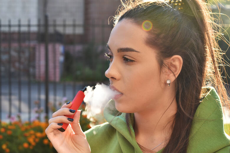 Młoda dziewczyna pali jednorazowe e-papierosy