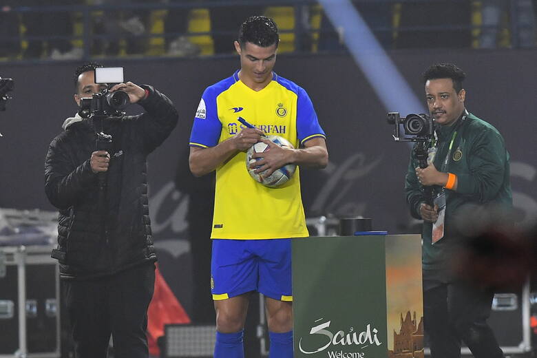 Cristiano Ronaldo podpisuje piłki podczas prezentacji w swoim nowym klubie An-Nassr na stadionie Mrsool Park w Rijadzie