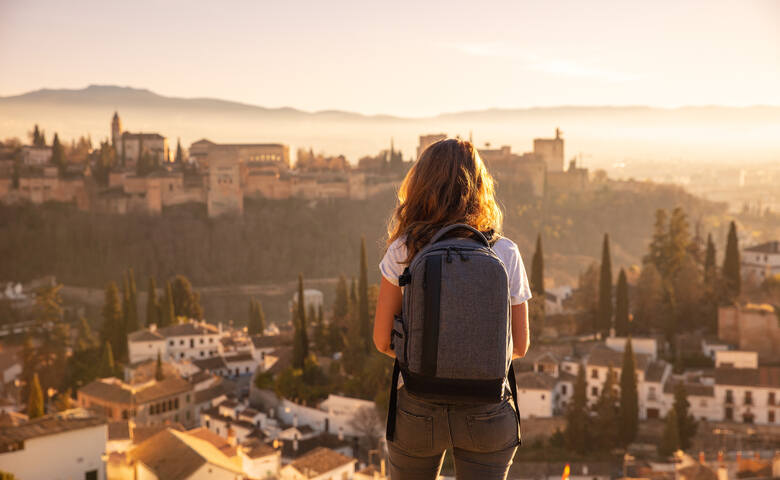 Kobieta podziwiająca panoramę miasta Alhambra w Hiszpanii