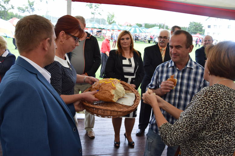Dorota Tracz z Wyciny i Remigiusz Smolec z Lipich Gór, starości dożynek, częstują zebranych chlebem dożynkowym.